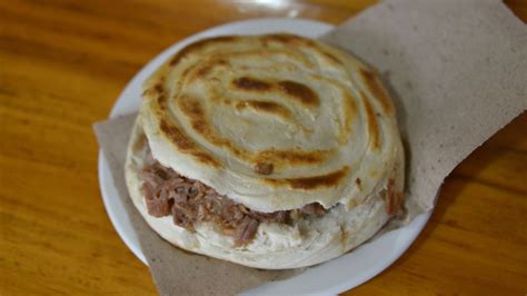  Roujiamo: Uma Sinfonia de Carne Suína Desfiada com Pão Assado e Crocante?